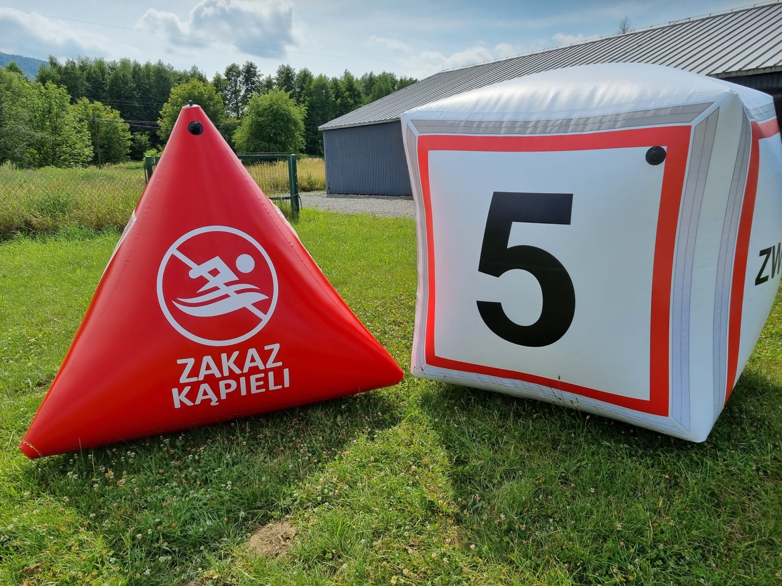 Pyramid buoy with a no-swimming sign and cube buoy numbered 5