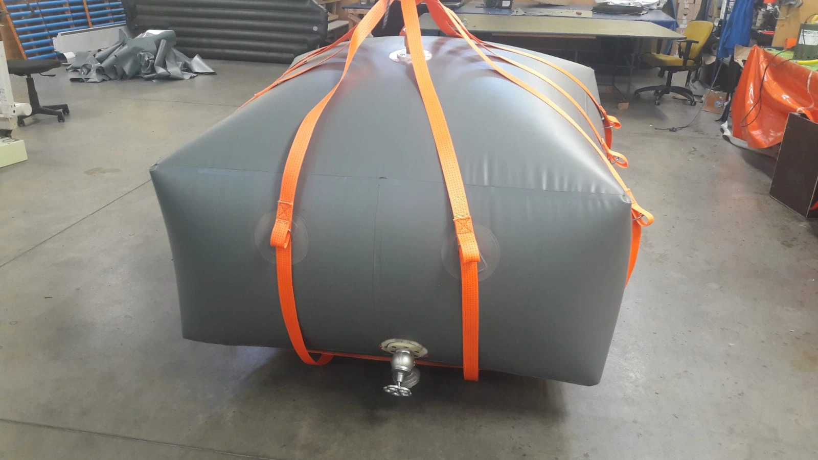 Grauer geschlossener Wassertank mit orangefarbenen Gurten — Archivaufnahme
